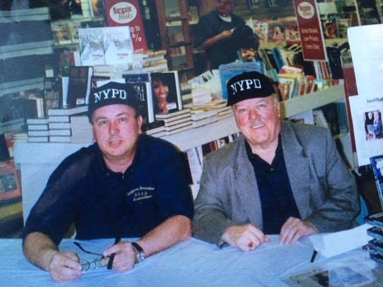 Two men sitting at a table with hats on.