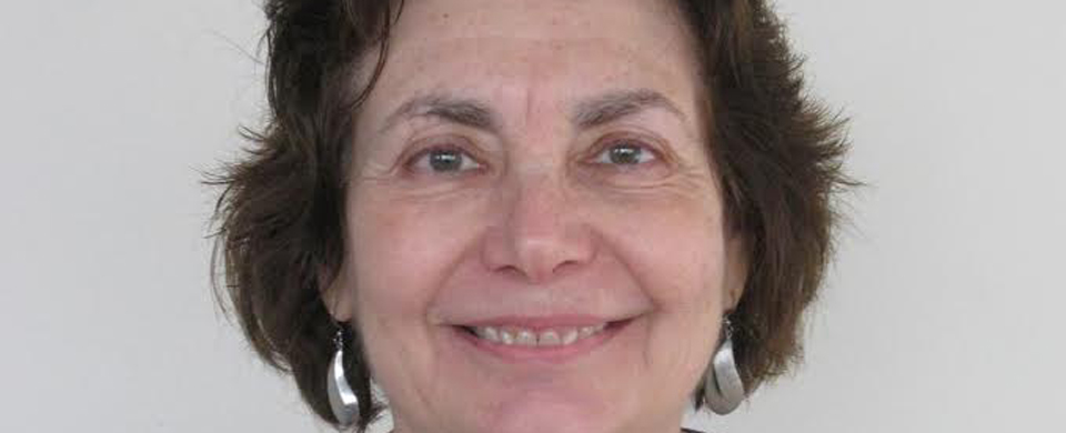 A woman with short hair and big earrings smiling.