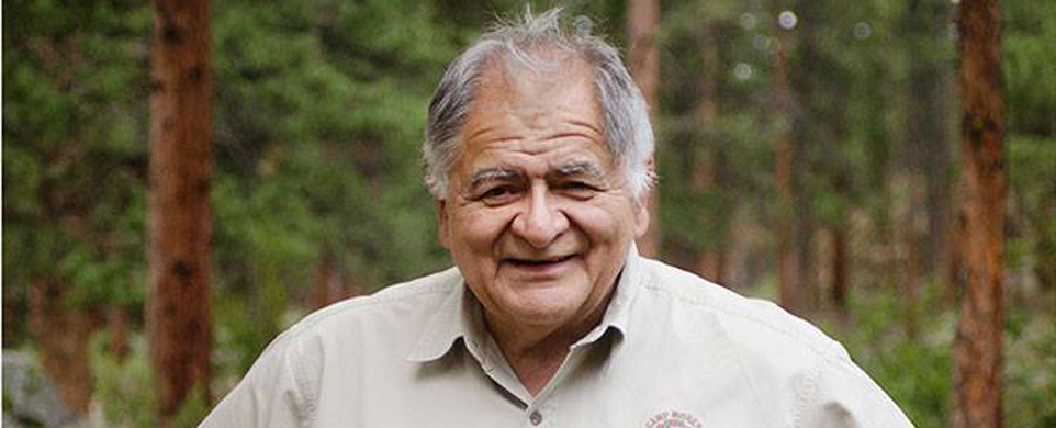 A man with grey hair and wearing a tan shirt.