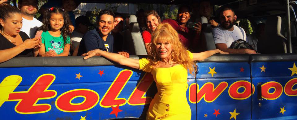 A woman in yellow dress standing next to two people.